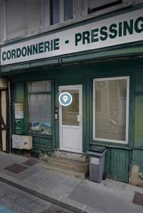 un bâtiment vert avec une porte et un panneau sur celui-ci dans l'établissement Moulins Studio cœur de ville de Saint Dizier, à Saint-Dizier
