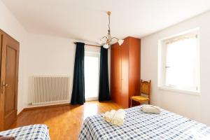 a bedroom with a bed with a blue and white blanket at Villa Villi in Terlago