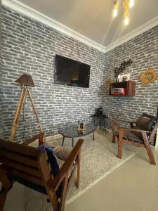 a living room with a brick wall at Magnifique appartement a louer à fnideq avec parking gratuit in Fnidek