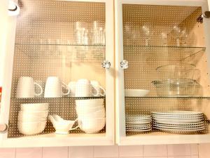 um armário com pratos, copos e pratos em Ann St Vacation Apartment Greenock United Kingdom em Greenock