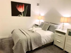 a bedroom with a bed with a red flower painting on the wall at Ann St Vacation Apartment Greenock United Kingdom in Greenock