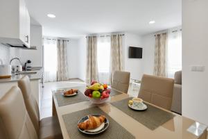 una cucina e una sala da pranzo con tavolo e cesto di frutta di Sonrisa Deluxe Apartments, Levante a Benidorm