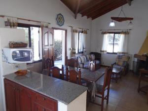 Aldea Blanca في ميرلو: مطبخ وغرفة معيشة مع طاولة وكراسي