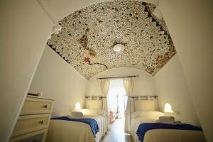 a attic room with two beds and a fancy ceiling at Casa Cueva Los Mosaicos in Guadix