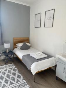 a small bedroom with a bed and a sink at Aragon House in Peterborough