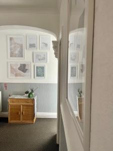 a hallway with a table and pictures on the wall at Aragon House in Peterborough