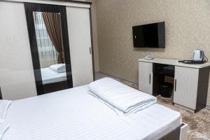 a hotel room with a bed and a television at AHMAD HOTEL in Samarkand