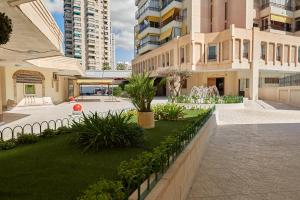a courtyard in a building with a lawn and fountain at Sonrisa Deluxe Apartments, Levante in Benidorm