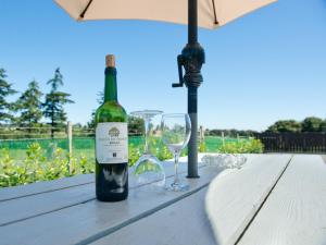 una bottiglia di vino e due bicchieri su un tavolo di legno di Maple Cottage a Drumshanbo-Glebe