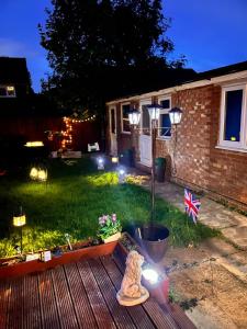 a yard with a garden with a flag and lights at Corby's FINEST EN-SUITE ROOM in Rockingham