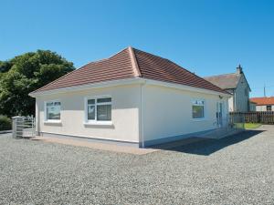 a small white house with a brown roof at Maple Cottage in Drumshanbo-Glebe