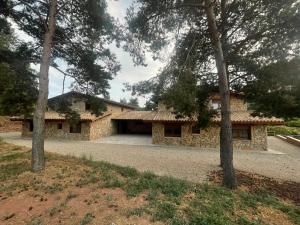 una casa de piedra con árboles delante de ella en Prades Vila Bella - Casa Molinets i Casa Borrianes, en Prades