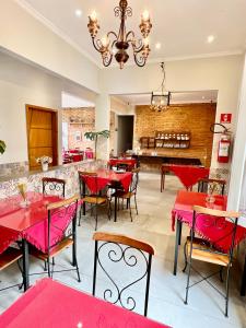 a dining room with red tables and chairs at HMG Suítes Inn Centro Histórico in Petrópolis