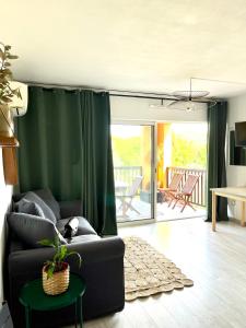 sala de estar con sofá y cortina verde en loumax, en Gassin
