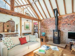 a living room with a couch and a brick wall at Kingfisher Cottage in Barkston