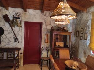 een kamer met een rode deur en een stenen muur bij Irene's Cottage House in Kértezi