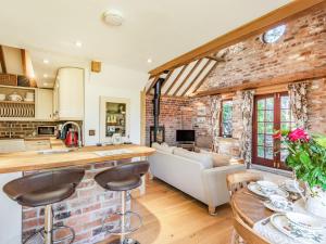 a kitchen and living room with a brick wall at Kingfisher Cottage in Barkston