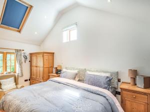 Un dormitorio con una cama grande y una ventana en Kingfisher Cottage, en Barkston