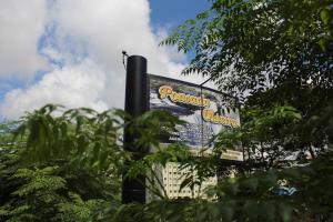 a large sign in front of a building with trees at Pousada Oliveira in Foz do Iguaçu