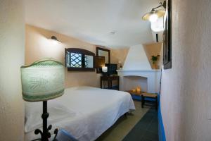 een slaapkamer met een bed en een lamp erin bij Castello Malicas in Galtellì