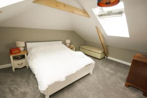 ein Schlafzimmer mit einem weißen Bett und einem Fenster in der Unterkunft Luxury three bedroom property with hot tub in West Wellow