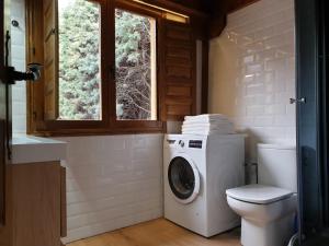 a bathroom with a washing machine and a toilet at Acogedora casa rural en la sierra de Madrid in Mataelpino