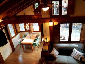 a room with a table and chairs and windows at Acogedora casa rural en la sierra de Madrid in Mataelpino