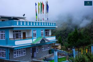 a blue building with flags on top of it at Divine's The Elite Zong in Lachung