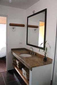 y baño con lavabo y espejo. en Belmira House Cedritos, en Bogotá