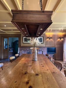 een grote eetkamer met een grote houten tafel en stoelen bij The GateHouse at Stansted in Great Hallingbury