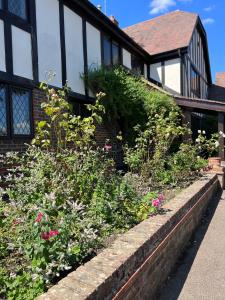 a brick retaining wall with flowers in front of a house at The GateHouse at Stansted in Hallingbury