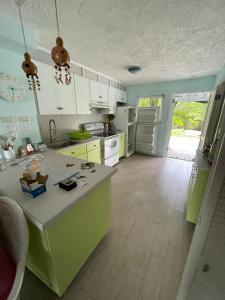 a kitchen with green and white cabinets and a counter at Sunny Villa in the Marina - Excellent Water Views in Jolly Harbour