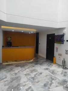 un vestíbulo con una pared amarilla y un mostrador en Hotel Cacique en Duitama