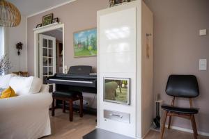 een woonkamer met een piano en een bank bij Villa Puistola & sauna, near Santa's Village in Rovaniemi