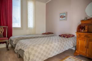 um quarto com 2 camas e uma cadeira vermelha em Villa Puistola & sauna, near Santa's Village em Rovaniemi