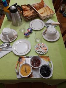 una mesa con platos de comida y una cesta de pan en Chambre d'hote chez Maud, en Saint-Sauveur-Marville