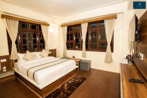 a bedroom with a large bed and windows at Divine's The Elite Zong in Lachung