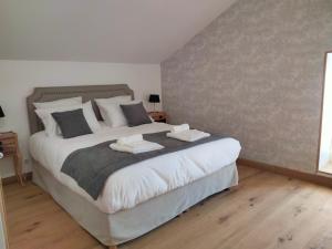 a bedroom with a large bed with two towels on it at Les Chambres de Moulière in Liniers +15 photos