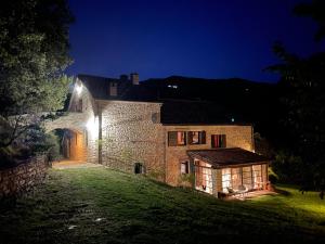 an old stone building with a lit up house at night at Ca' Maranghi Holiday House in Palazzuolo sul Senio