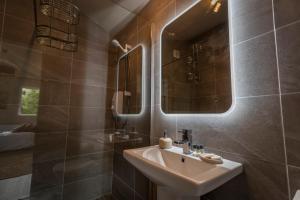 ein Bad mit einem Waschbecken und einem Spiegel in der Unterkunft The Rose Suite Kenmare in Kenmare