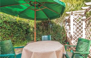 una mesa con una sombrilla verde y 2 sillas en Holiday Home Rowy Ul Bukowa, en Rowy