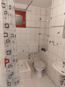 a white bathroom with a toilet and a sink at Ferienwohnung J10, Playmobil Funpark Zirndorf Nürnberg in Zirndorf