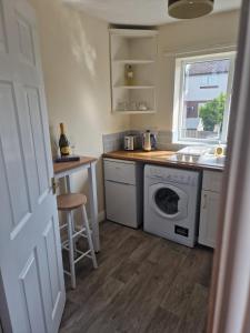 a kitchen with a washer and a sink and a stove at Lovely 2 bed appt with parking only 5 mins from M6 or Carlisle in Carlisle