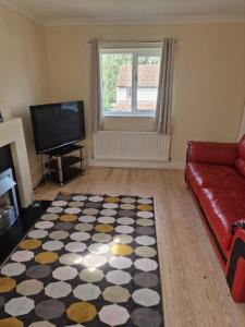 a living room with a couch and a television at Lovely 2 bed appt with parking only 5 mins from M6 or Carlisle in Carlisle