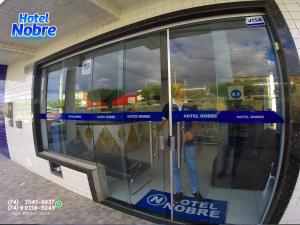odbicie osoby w szklanych drzwiach w sklepie w obiekcie Hotel Nobre w mieście Senhor do Bonfim