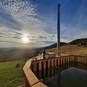 a hot tub on a deck with a view of the mountains at Vikendica RANKOVIĆI in Mokra Gora