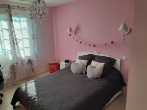 - une chambre avec des murs roses et un lit avec des oreillers dans l'établissement CLOS DES ROMPUDES, à Aramon