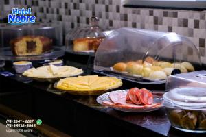 a buffet line with cheese and other food items at Hotel Nobre in Senhor do Bonfim