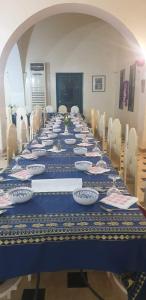 einem langen Tisch mit Tellern und Geschirr darauf in der Unterkunft Hotel Pansy in Qaşr Ghīlān