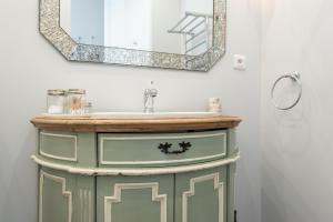 een badkamer met een wastafel en een spiegel bij Le Dandy - Grand T3 au pied du métro Garibaldi in Lyon